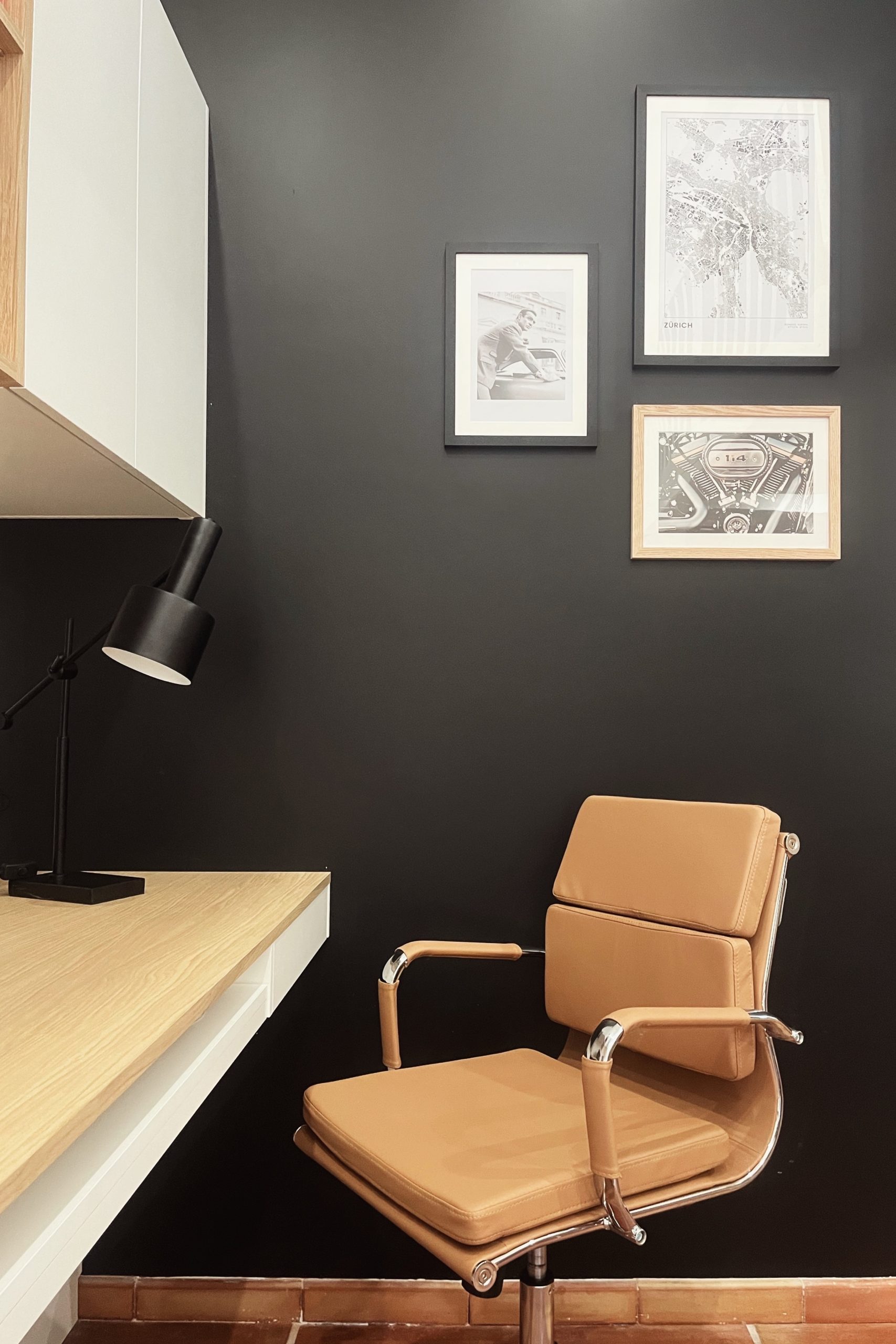 Bureau sur mesure avec un mur noir, une chaise en cuir et une lampe de bureau
